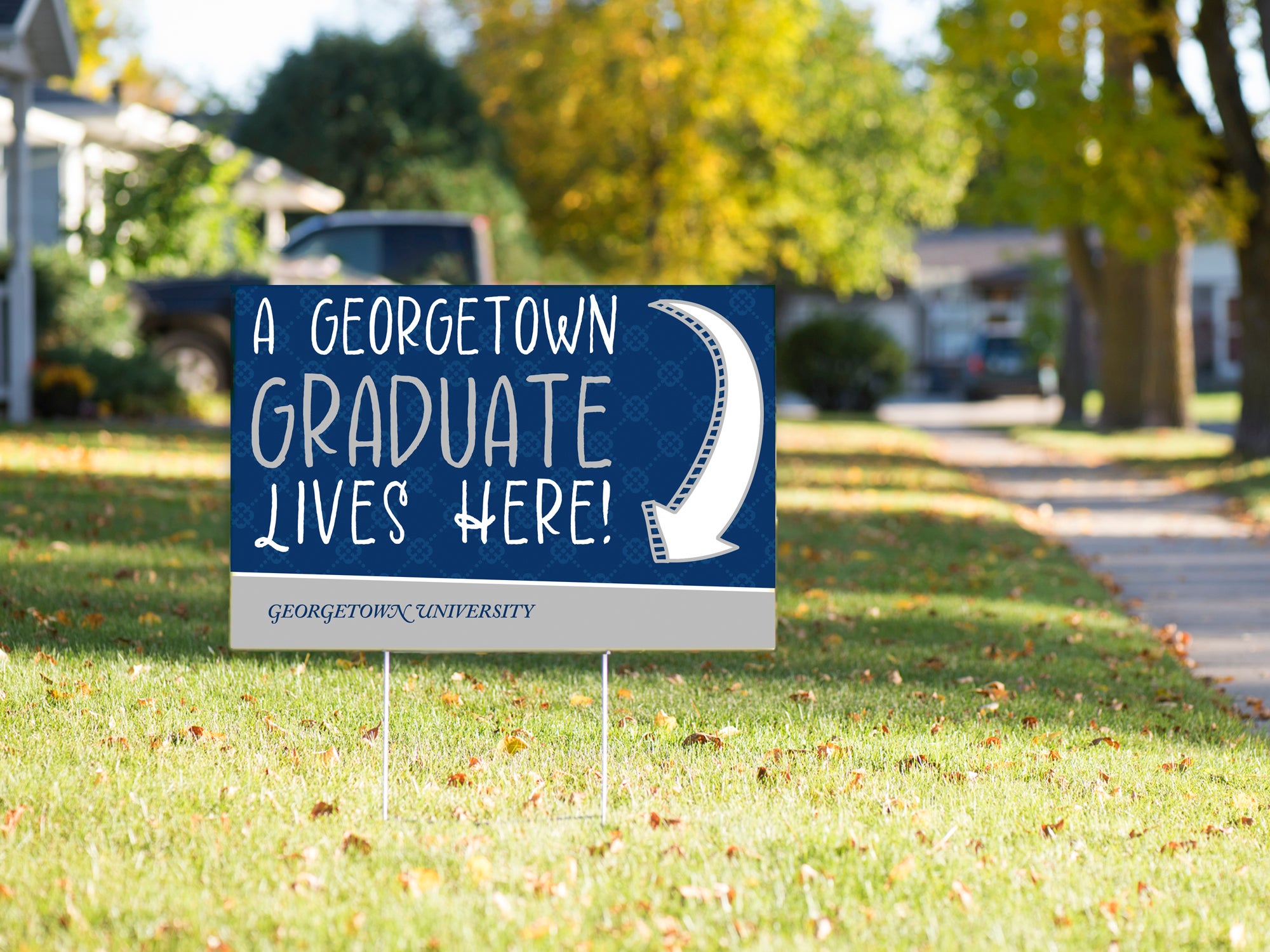 A yard sign on a grassy lawn reads 